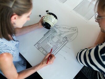 Frau die sich einen Plan eines technischen Gerätes anschaut